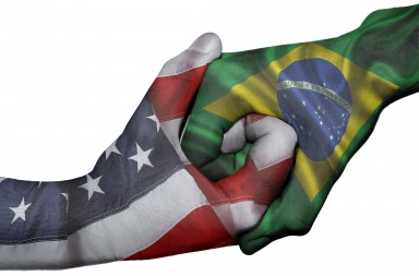 Diplomatic handshake between countries: flags of United States and Brazil overprinted the two hands